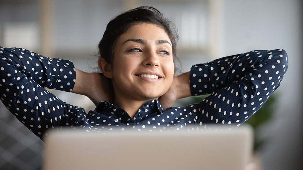 woman smiling sitting in front of a laptop
